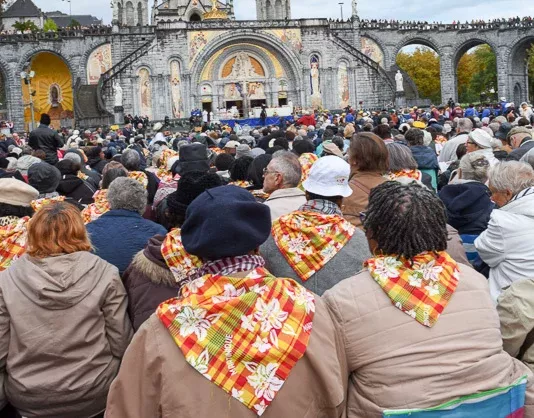 Foule de pèlerins à Lourdes portant des foulards