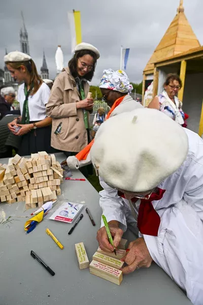 Jeunes gens écrivent sur des blocs de bois lors d'un événement