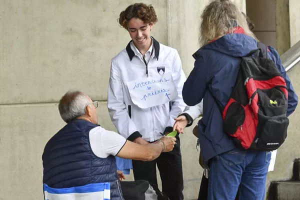 Jeune homme recueillant des intentions de prière.