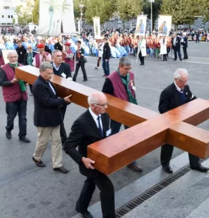 Hommes portant une grande croix en bois lors procession religieuse