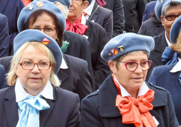 Groupe de femmes en uniformes bleu marine avec bérets bleus et foulards colorés.